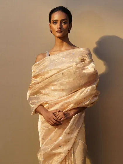 A closer look at the styling of the gold tissue saree, with a statement brooch used to hold the drape in place.