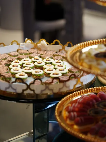 An elegant dessert display on golden trays, featuring a variety of our bite-sized patisserie. The presentation is as luxurious as the desserts themselves.