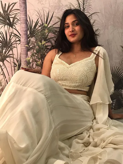 A serene shot of our off-white fusion set, featuring a fully beaded crop top and a flowing tiered skirt with a pre-attached ruffled dupatta.