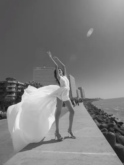 The same powerful pose, but in black and white. It highlights the form, movement, and emotion of the shot.