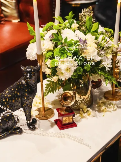 The details on the table, from the texture of the panther to the glow of the candles, create a rich and layered vignette.