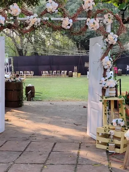 A beautiful rustic entrance detail, featuring a personalized welcome sign on an easel. The area is decorated with wooden crates, a ladder shelf, and floral arrangements for a charming, curated look.