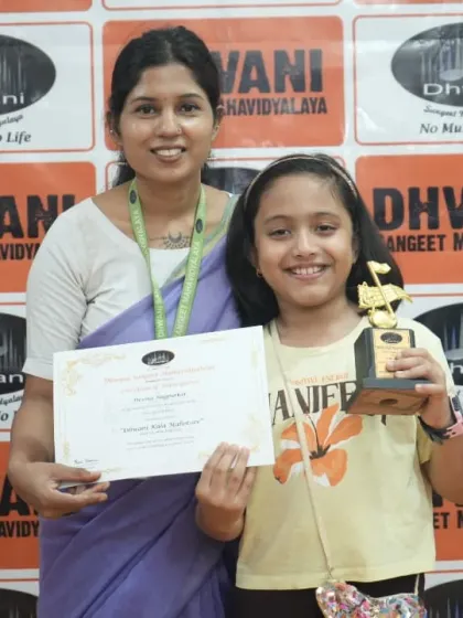 A faculty member awards a young student for her excellent performance.