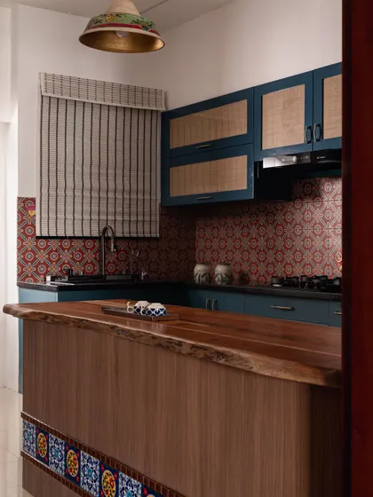 A glimpse into the deep blue kitchen from the foyer. The design uses bold color and pattern to create a strong statement.