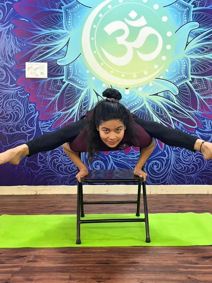This arm balance on a chair, a variation of Tittibhasana (Firefly Pose), is a creative way to build upper body and core strength.