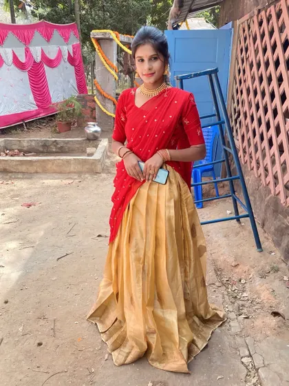 A client in a simple yet elegant red and gold Langa Davani, a perfect rental for a small family function or puja.