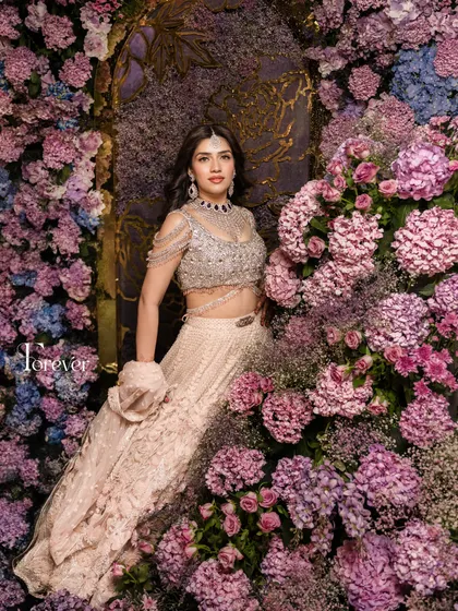 A bride deserves a backdrop as stunning as she is. This photo corner features a lush wall of purple and pink hydrangeas and roses, creating a rich, textured floral environment for beautiful portraits.