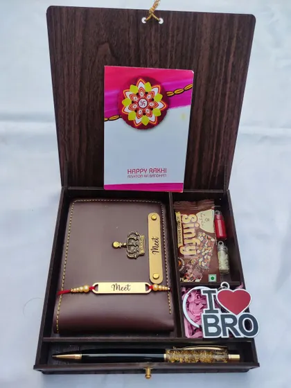 A premium Rakhi gift set in a wooden box, containing a personalized passport holder, a matching rakhi, a pen, and chocolates.