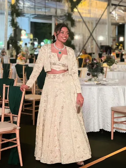 The complete look for Vaishnavi's wedding attendance. The custom-stitched brocade lehenga is beautifully complemented by the radiant makeup and sophisticated hairstyle, perfect for a modern wedding guest.