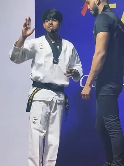 Continuing the self-defense demonstration on stage. My hands are up in a passive guard, showing how to de-escalate a situation while remaining ready to defend.