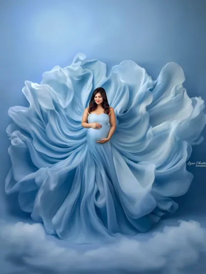 A full-length view of this incredible light blue gown, where the fabric itself becomes a work of art. The way it billows and flows creates a stunning, ethereal maternity portrait.