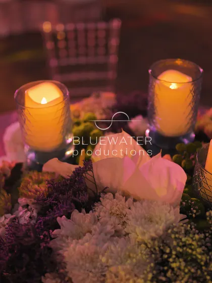 As evening falls, the candles in the centerpiece are lit, creating a warm and romantic glow on the dinner table.