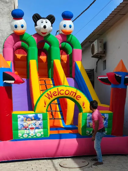 This 12x18 foot 3-slider bouncy shows a person for scale, highlighting its large and impressive size for events.
