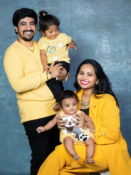 A bright and cheerful family of four, all dressed in coordinating yellow outfits for a vibrant studio portrait.