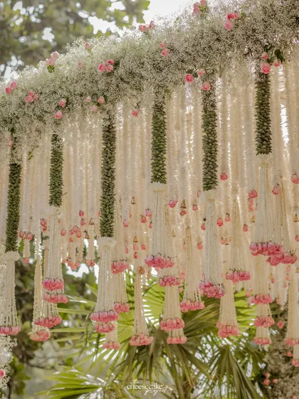 The full arch of the mandap, showcasing how the floral design extends from the pillars to the canopy, creating a complete floral haven.