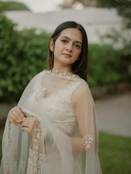 Soft, romantic, and utterly chic. This engagement look features a minimal base, subtle contouring, and a natural lip color to complement her ethereal white lehenga, perfect for an evening of celebration.