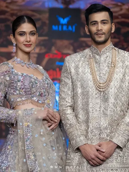 A close-up of the groom's gold sherwani with floral multicolor embellishments. The intricate work and regal bearing define the elegance of the Aurous collection.