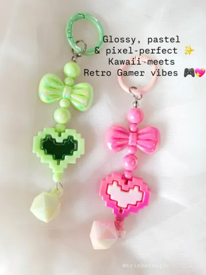 Where kawaii meets retro gamer. These pixel heart charms in mint green and pink are a fun and trendy accessory, complete with a cute bow and geometric bead.