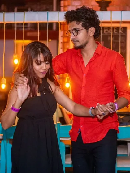 A stylish and focused pair. The red shirt and black dress are a classic, powerful combination.