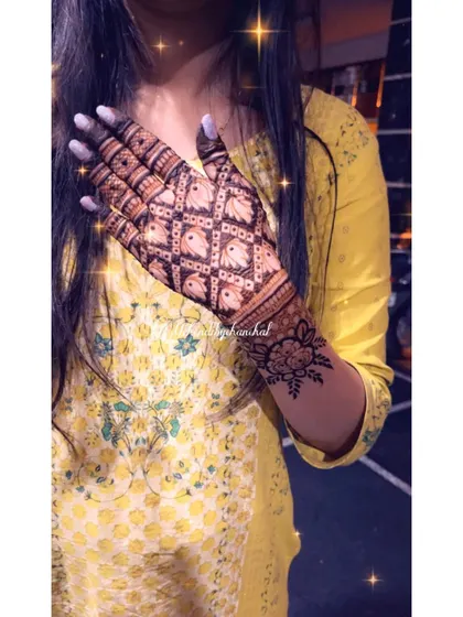A unique design with a jaal pattern made of tiny elephants, covering the back of the hand.