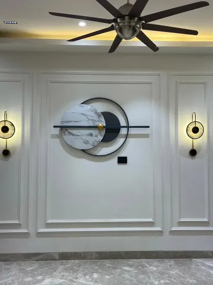 A full view of the finished wall, holding the whole room's beauty. The central art piece is perfectly balanced by the sconces and molding.