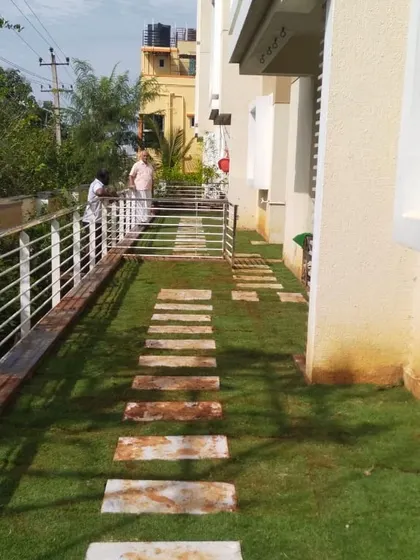 A side yard with a new lawn and a stone stepper path running alongside the house. This project demonstrates how I can transform narrow or underutilized spaces into attractive garden areas.