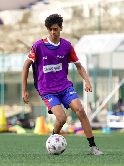 A player in a purple bib looks for a pass during a training game. Our drills focus on developing vision and decision-making.