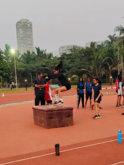 A female athlete executes a powerful box jump during a training session. I am committed to building strength and confidence in all my athletes, helping them reach new heights.