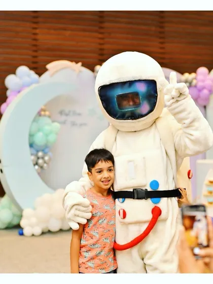 An astronaut mascot poses with a guest at our 'First Trip Around the Sun' party. These character interactions create amazing memories.