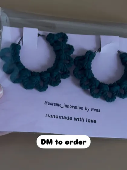 A pair of my crochet hoop earrings in a deep bottle green. The scalloped edge design gives them a unique, floral-inspired look.