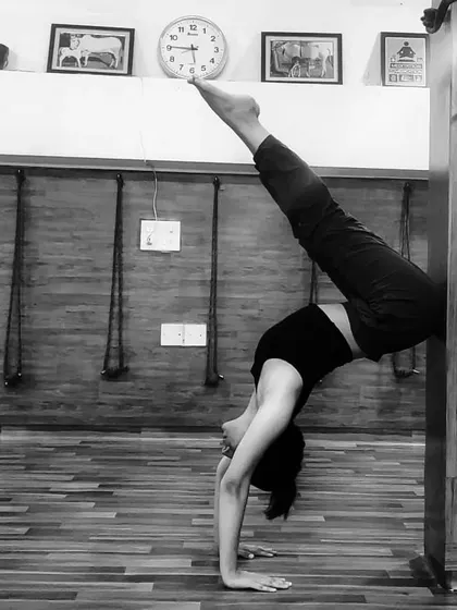 Using a wall as a prop to work on a forearm stand split. The wall provides support and helps build the confidence and alignment needed for freestanding inversions.