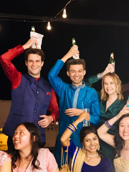 A hilarious and candid moment of guests balancing beer bottles on their heads during the party.