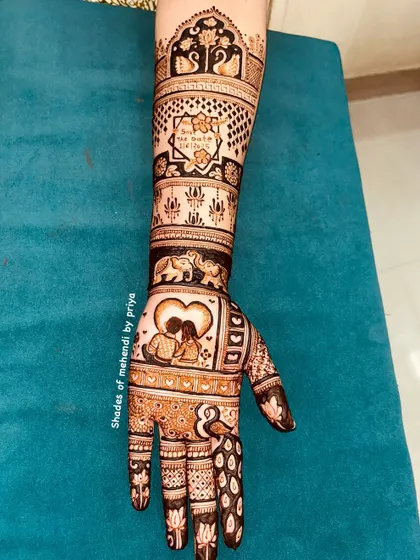 A full arm of story-telling mehendi, perfect for a festival or special occasion. It includes various motifs like couples, elephants, and swans.