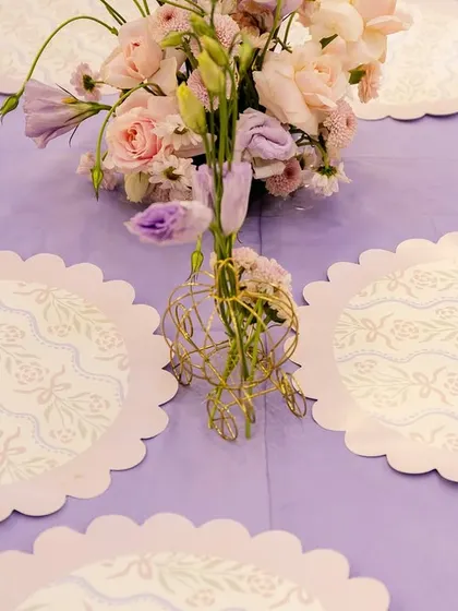 Custom scalloped placemats with a delicate pattern complemented the lavender tablecloths and soft floral arrangements at the princess party.