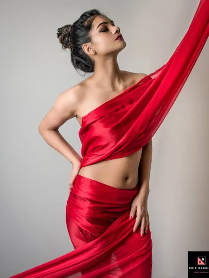 A dynamic shot from the 'Crimson Dreams' series, where the model stands draped in red fabric. Her pose and the flow of the material create a sense of movement and passion.