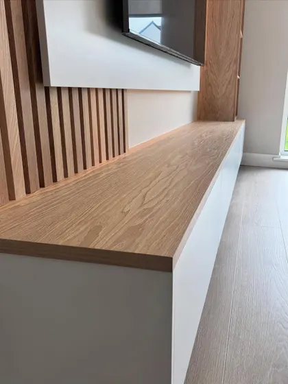 A close-up shot of the TV console, highlighting the clean joinery and the beautiful grain of the wood laminate.