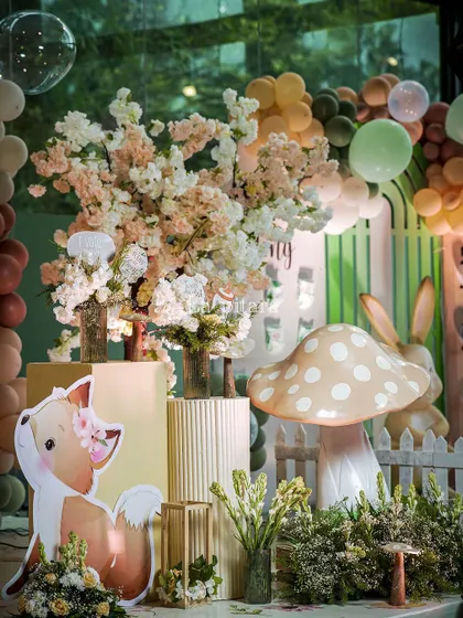 A detail shot from the woodland theme, showing a cute fox cutout next to lush floral arrangements and a large decorative mushroom. Every element was carefully chosen to build the enchanting narrative.
