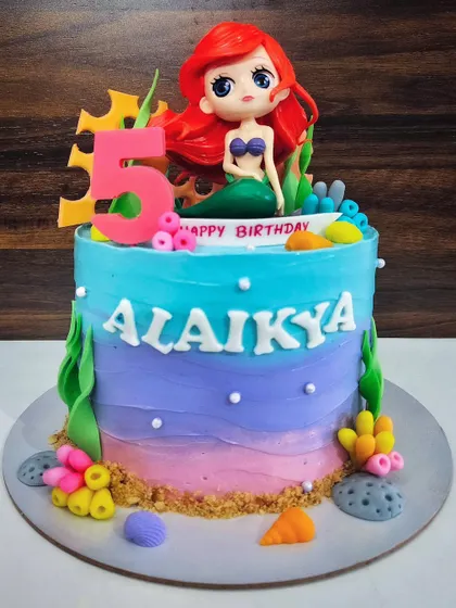 A dreamy mermaid cake for Alaikya's 5th birthday. This ombre cake features a beautiful Ariel doll topper and lots of underwater details like coral and seashells.