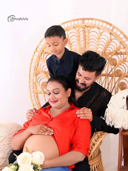An intimate and modern family portrait from one of our indoor studio sessions. The family gathers closely in a relaxed setting, showcasing a comfortable and personal style of photography that focuses on connection and anticipation.