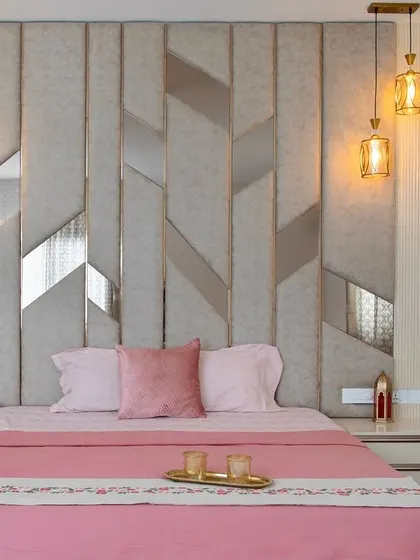 A closer look at the bespoke headboard, featuring upholstered panels and metallic inlays. The design adds texture and sophistication, making the bed the undeniable hero of the room.