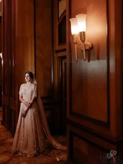 A full-length shot of the bride in her elegant pastel lehenga, showcasing the grandeur of her wedding attire.