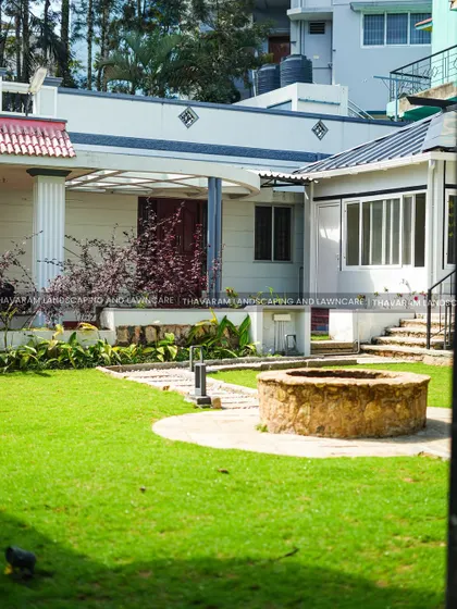 This wide shot shows how the stone well and pathway are integrated into the larger landscape of the property, connecting different areas of the home.