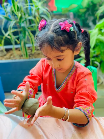 A moment of quiet concentration during our festive workshop. This young participant is carefully shaping her clay Ganesha, fully engaged in the creative process.