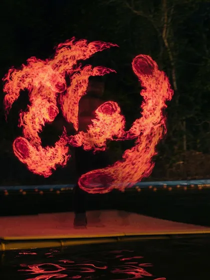 An abstract, fiery pattern created by an LED poi artist. These performances are a core part of the festival atmosphere, going beyond just the sport of climbing.