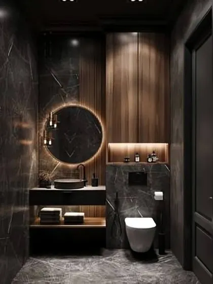 A dramatic and moody bathroom with floor-to-ceiling dark marble tiles and wood paneling. The lighting is carefully placed to highlight the textures and create a sophisticated ambiance.