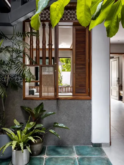 A beautifully detailed wooden window looks out from an interior room into the central courtyard, enhancing the home's internal connectivity.