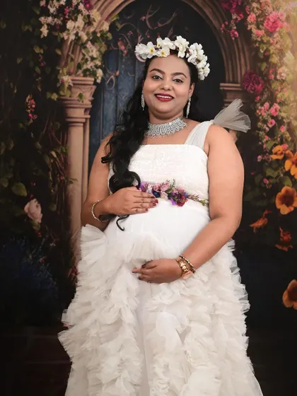 A close-up of a client looking radiant in our white ruffle maternity gown, perfect for capturing that special pregnancy glow.