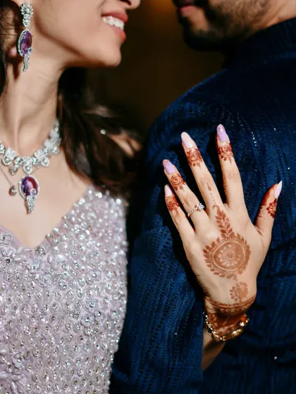A detailed shot highlighting the bride's beautiful engagement ring, henna, and stunning diamond necklace, capturing the essence of engagement glamour.