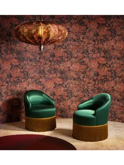 Jewel tones and a rich floral pattern create a decadent, luxurious mood. This wallpaper, paired with emerald green chairs, demonstrates how I use deep, saturated colours and textures to design an opulent and inviting drawing room.