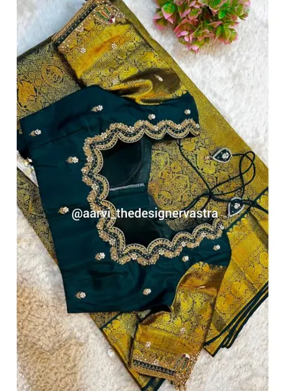 A dark green blouse with a beautiful scalloped back design, framed with intricate gold embroidery.